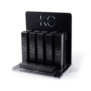 Kensi Cosmetics eyebrow gel display with ten sleek black boxes neatly arranged on a transparent platform, featuring the KC logo in white